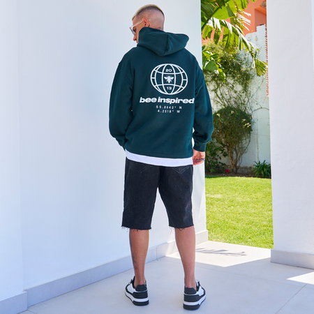Bee Inspired Mata Hoodie in Pine Green, oversized hoodie with a bold rear graphic print, styled shot