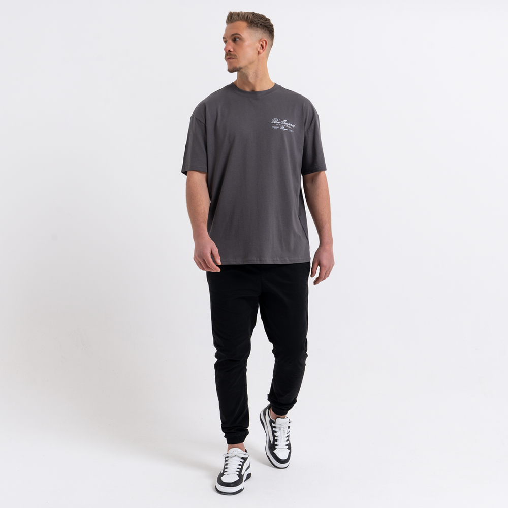 Man wearing a grey t-shirt and black cargo pants on a white background