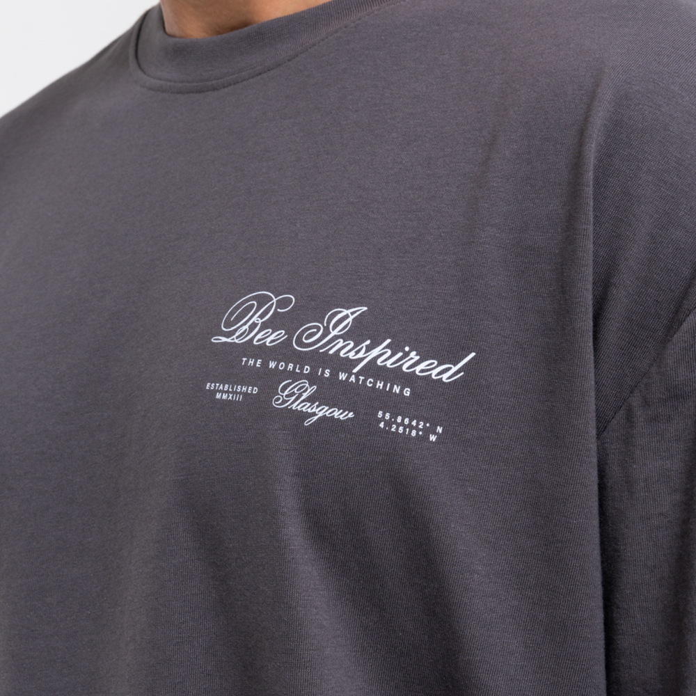 Dark grey t-shirt with 'Bee Inspired' text on a plain background