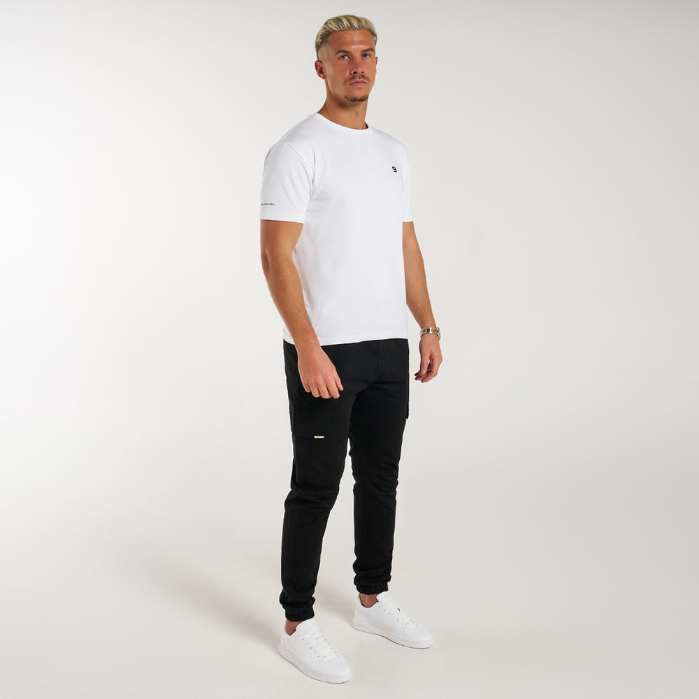 Rivero Cargo Pants in black with a metal branded pocket label