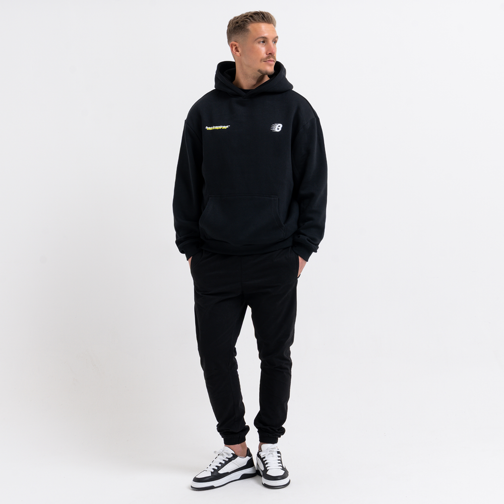 Man wearing a black hoodie and cargo pants with a logo on a white background