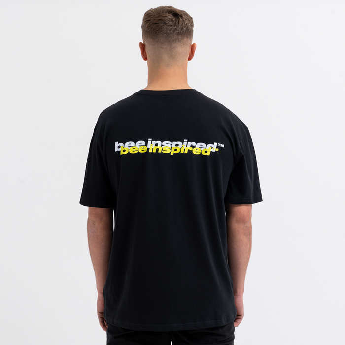 Person wearing a black t-shirt with 'Bee Inspired' text on the back against a white background