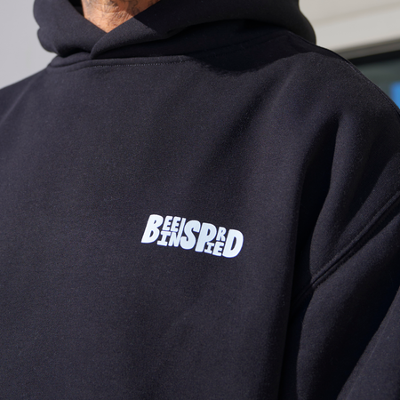 Bee Inspired Aguirre Hoodie in Black/Blue, relaxed fit hoodie with a raised graphic print and kanga pocket, close-up