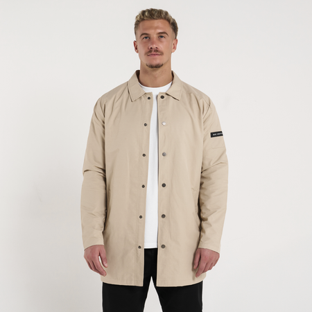 Bee Inspired Hanley Trench Coat in Sand, slim fit trench coat with a collared neck and branded snap fastenings, styled shot