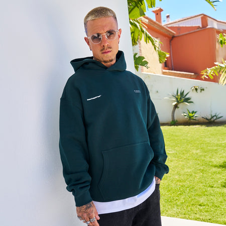 Mata Hoodie in pine green with a relaxed graphic look