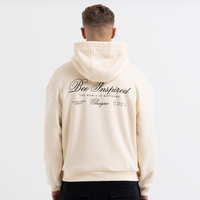 Man wearing a sand hoodie with text on the back against a white background