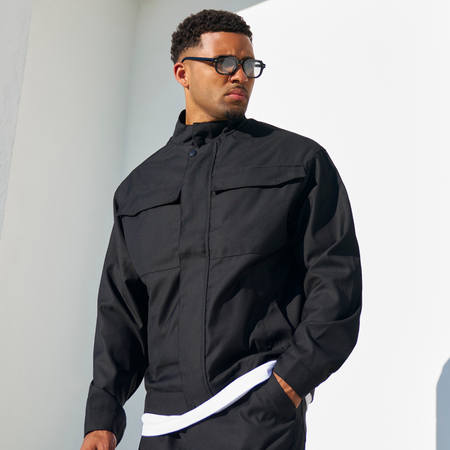 Bee Inspired Onana Jacket in Black, utility-style jacket with tonal Bee branding and chest pockets, styled lifestyle shot