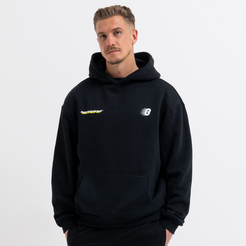 Man wearing a black hoodie with brand logos on a light gray background