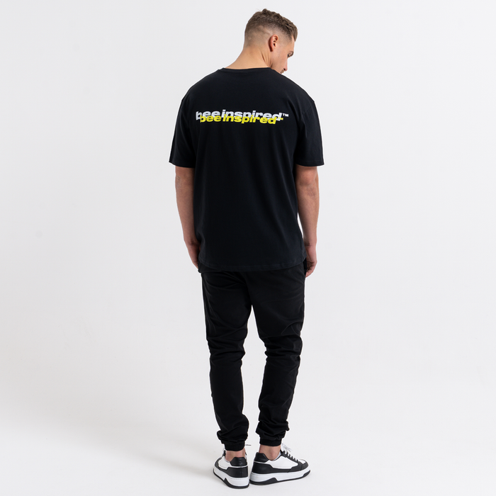 Person wearing a black t-shirt with text on the back against a white background