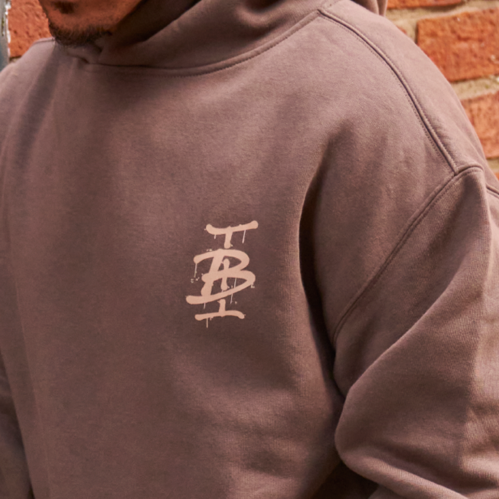Bee Inspired Tonali Hoodie in Walnut, close-up of graffiti-style chest graphic detail